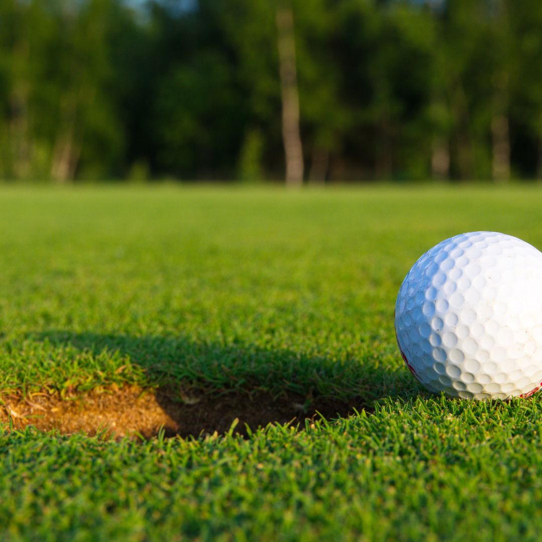 golf ball next to hole